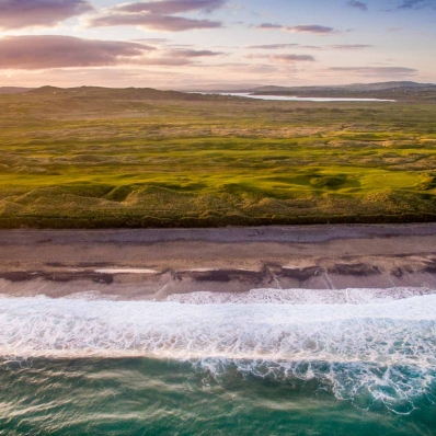 An aerial photo of the Ballyliffin Golf Club Glashedy Golf Course and the crashing waves of the Atlantic.