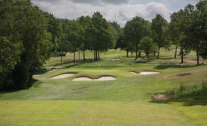 A green complex surrounded by bunkers at Sand Moor Golf Club.