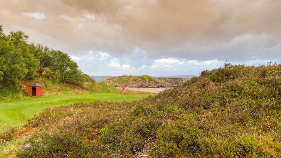 The short 7th with beach and bay as a backdrop.